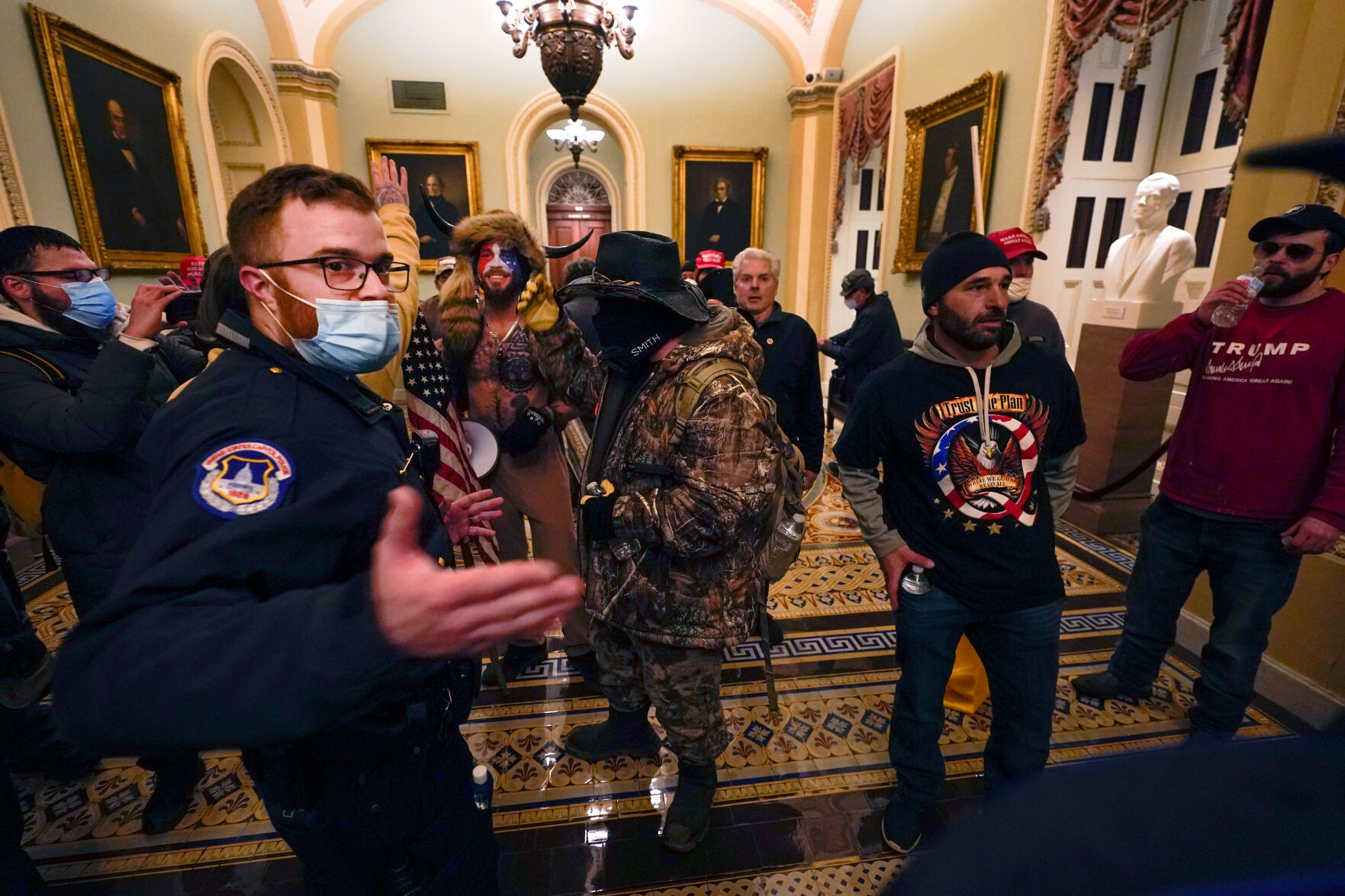 Pro-Trump rioters walk as U.S. Capitol Police officers watch
